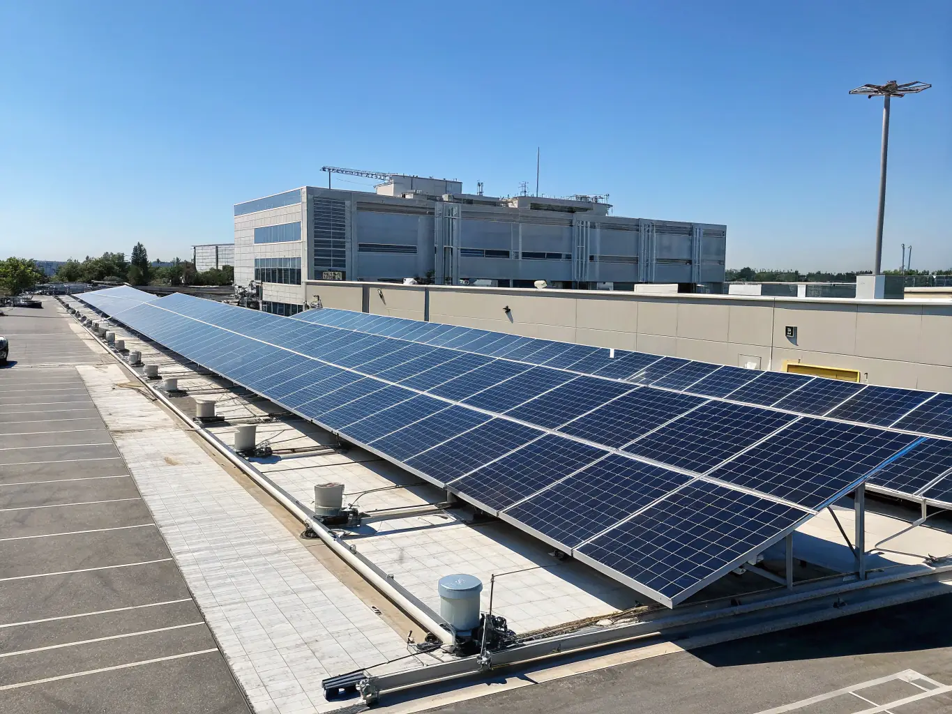 A wide shot of a solar panel installation at a New Mexico school, with a focus on the panels and the school building in the background, symbolizing reliable energy for the community.